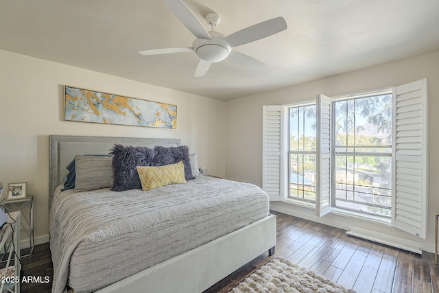 bedroom with ceiling fan, dark hardwood / wood-style flooring, and multiple windows