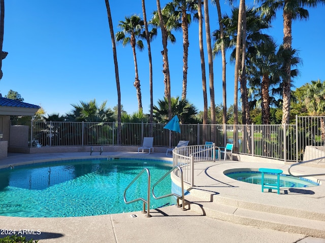 view of swimming pool with a patio area and a hot tub