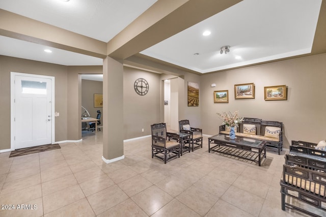 living room with a tray ceiling and light tile patterned floors