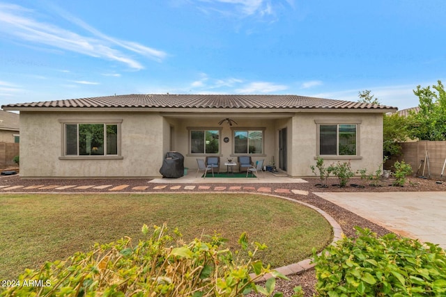 rear view of house featuring a yard, ceiling fan, and a patio area