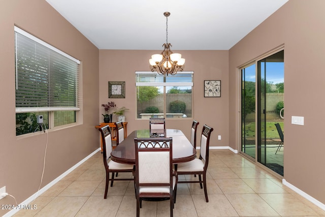 tiled dining room featuring an inviting chandelier