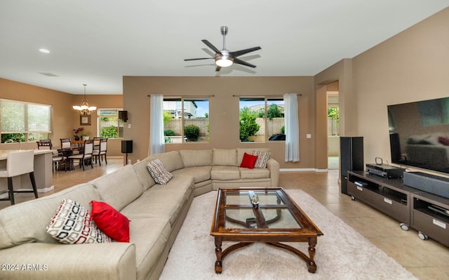 tiled living room with ceiling fan with notable chandelier