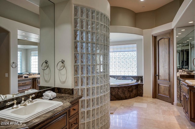 bathroom featuring tiled bath, tile patterned floors, and vanity