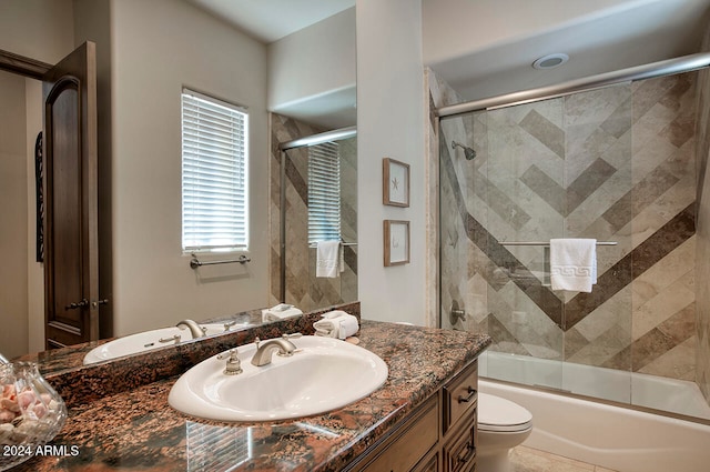 full bathroom featuring toilet, bath / shower combo with glass door, and vanity