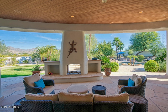 view of patio with an outdoor fireplace and a mountain view