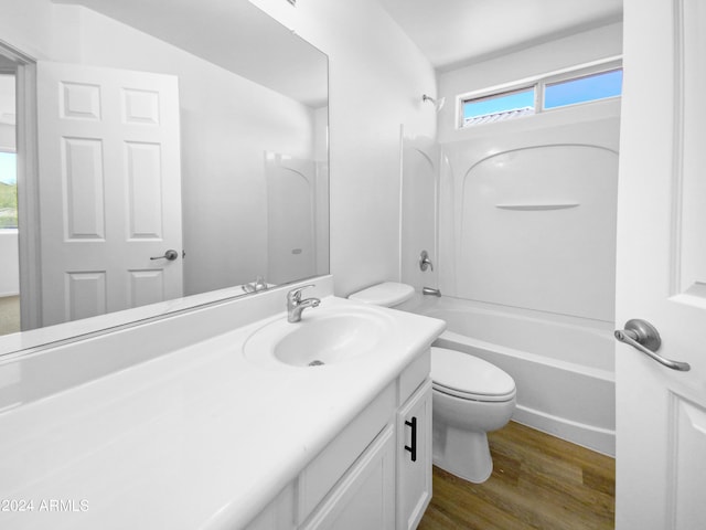 full bathroom featuring a wealth of natural light, vanity, hardwood / wood-style flooring, and washtub / shower combination