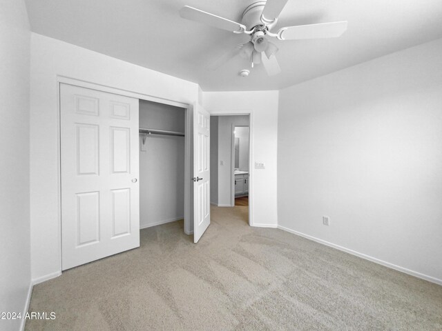 unfurnished bedroom featuring light colored carpet, a closet, and ceiling fan