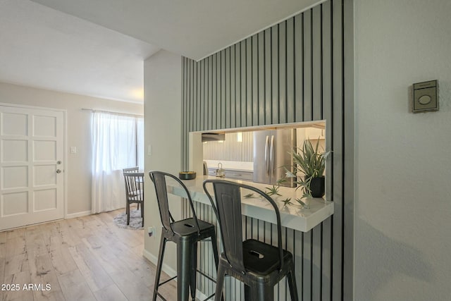 details featuring wood finished floors, freestanding refrigerator, and baseboards