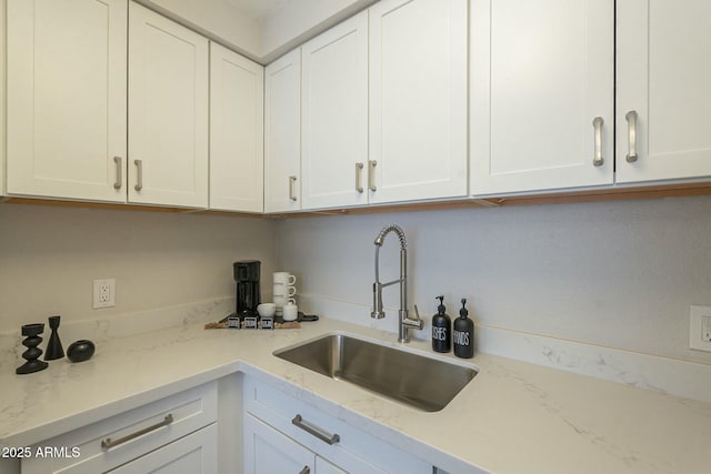 kitchen featuring a sink and white cabinets