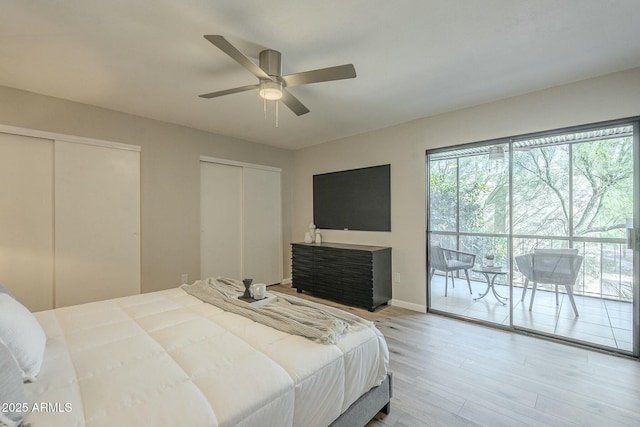 bedroom with access to exterior, ceiling fan, two closets, and wood finished floors