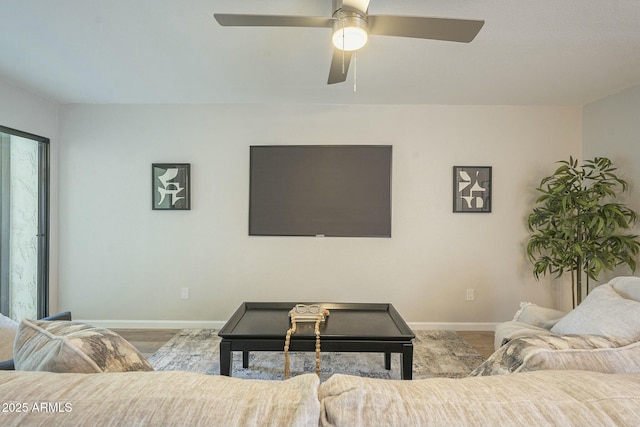 living room featuring baseboards and a ceiling fan