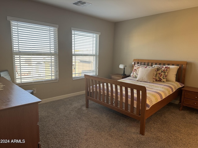 bedroom with multiple windows, baseboards, visible vents, and carpet floors