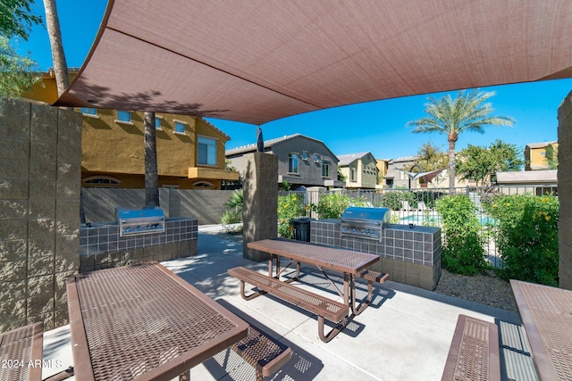 view of patio featuring grilling area, fence, a residential view, outdoor dining area, and area for grilling