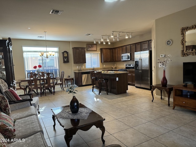 living room with light tile patterned floors, visible vents, baseboards, and a notable chandelier