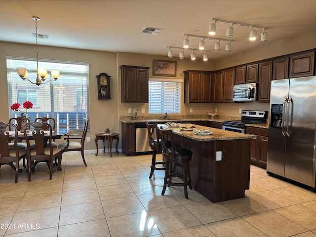 kitchen with light tile patterned floors, stainless steel appliances, dark brown cabinetry, and visible vents