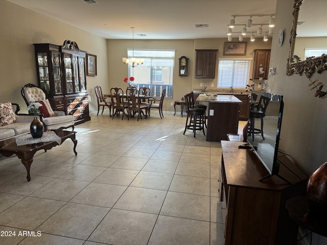 living area featuring a chandelier, baseboards, visible vents, and light tile patterned flooring