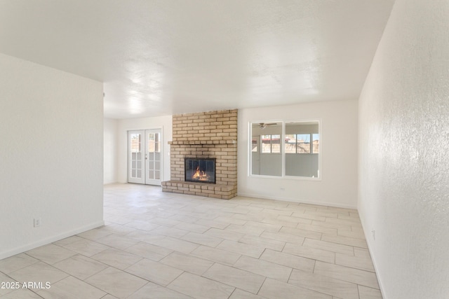 unfurnished living room with a fireplace and french doors