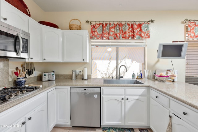 kitchen featuring appliances with stainless steel finishes, sink, and white cabinets