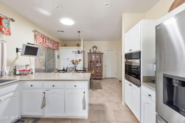 kitchen with kitchen peninsula, stainless steel appliances, decorative light fixtures, a chandelier, and white cabinets