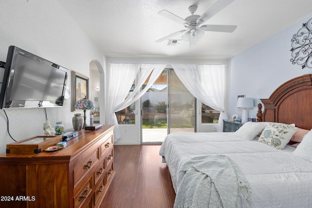 bedroom featuring dark wood-type flooring, access to exterior, a textured ceiling, and ceiling fan