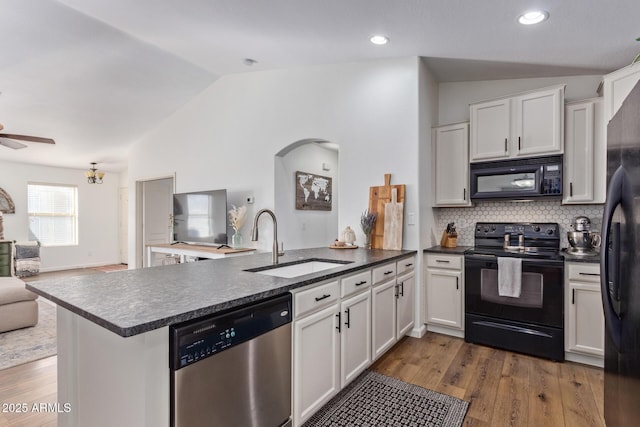 kitchen featuring lofted ceiling, sink, kitchen peninsula, and black appliances