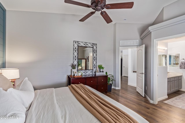 bedroom featuring vaulted ceiling, dark hardwood / wood-style floors, ceiling fan, and ensuite bathroom