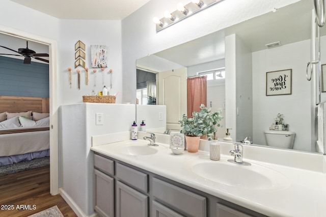 bathroom featuring ceiling fan, vanity, toilet, and wood-type flooring