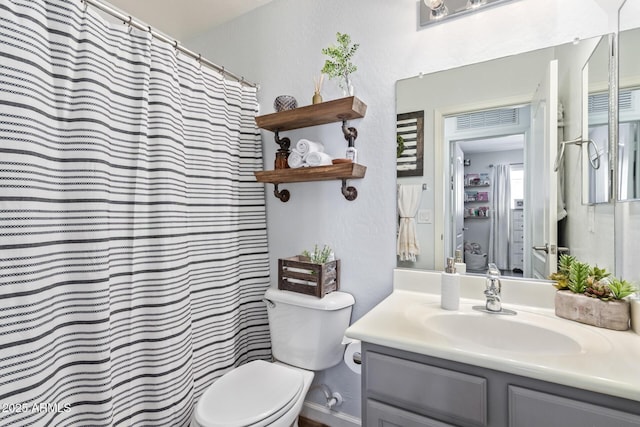 bathroom featuring vanity, toilet, and curtained shower