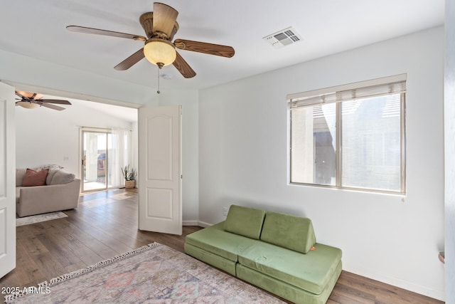 living room featuring wood-type flooring and ceiling fan