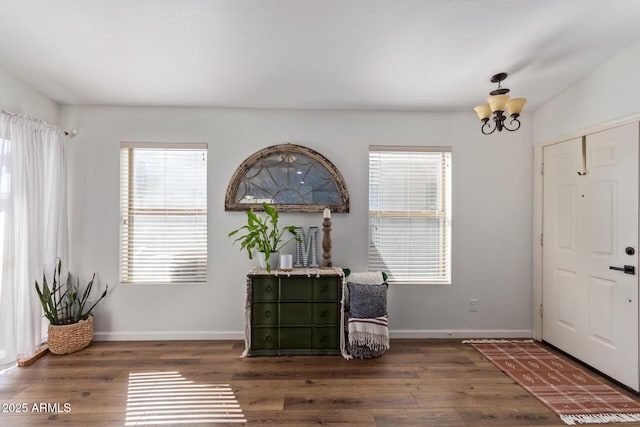 foyer with dark hardwood / wood-style flooring and a notable chandelier