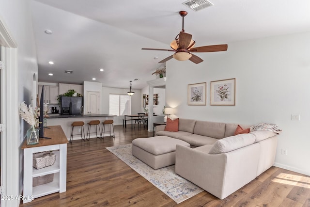 living room with lofted ceiling, dark hardwood / wood-style floors, and ceiling fan