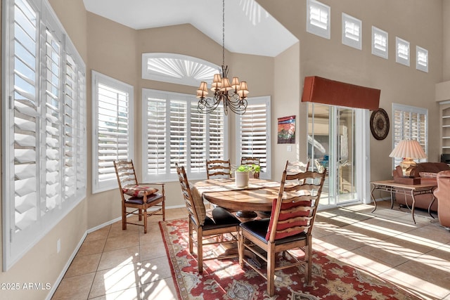 dining area with a wealth of natural light, tile patterned flooring, high vaulted ceiling, and an inviting chandelier