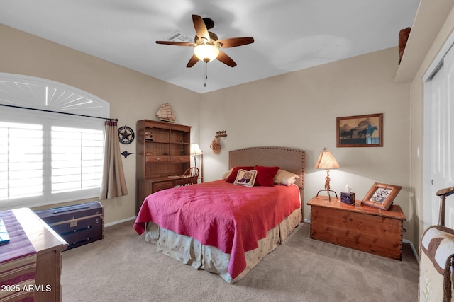 bedroom with ceiling fan, light colored carpet, and a closet