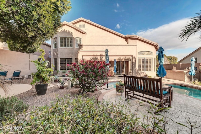 rear view of house with a patio and a fenced in pool