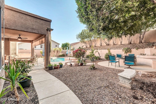 view of yard featuring ceiling fan, a fenced in pool, and a patio