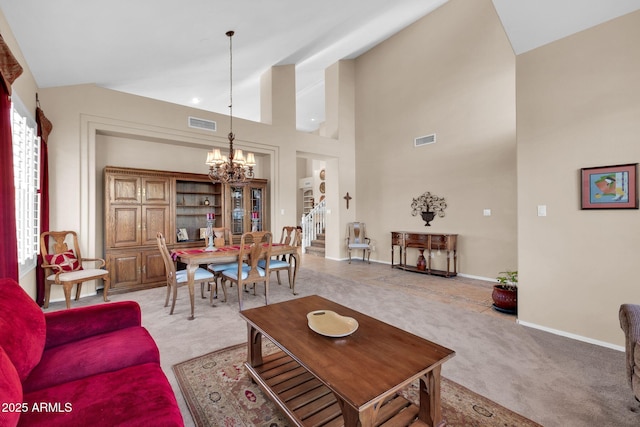 living room with a chandelier, a high ceiling, and light colored carpet