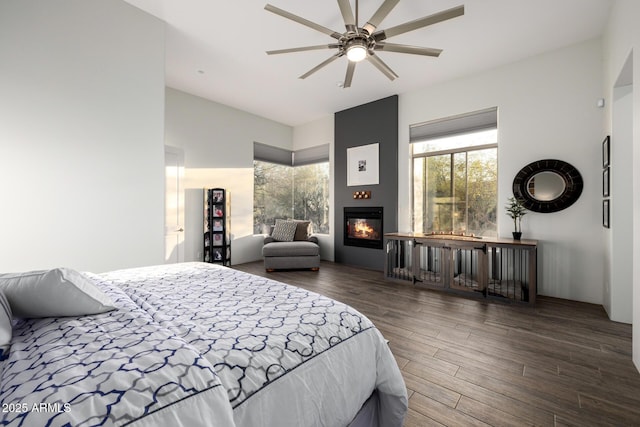 bedroom with a large fireplace and wood finished floors