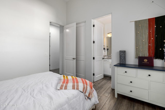 bedroom featuring dark wood-type flooring and connected bathroom