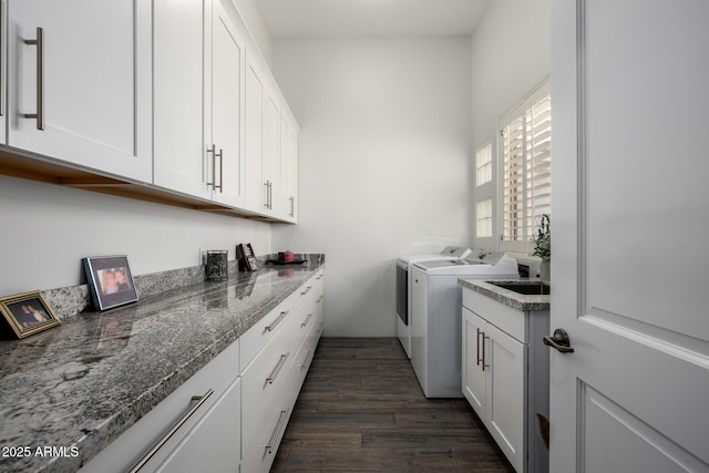 laundry area featuring dark wood-style flooring, washing machine and clothes dryer, and cabinet space