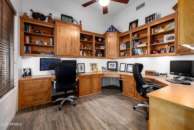 office area with a ceiling fan, visible vents, dark wood-style flooring, and built in study area