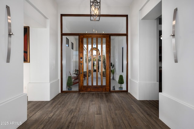 entrance foyer with an inviting chandelier and dark wood-style flooring