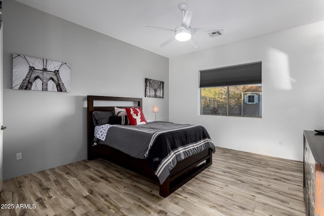 bedroom with wood finished floors, visible vents, and a ceiling fan