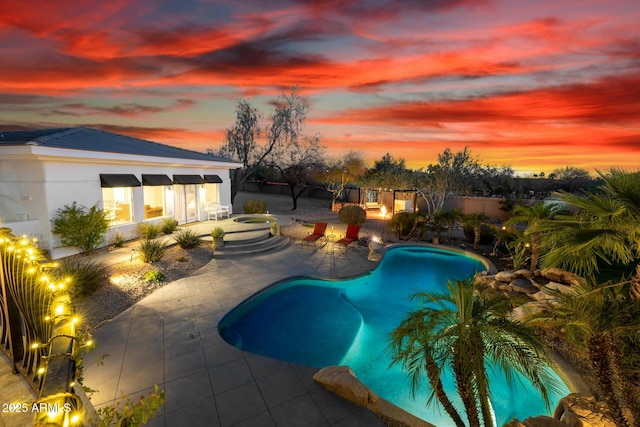 pool at dusk with a patio, a hot tub, and an outdoor pool