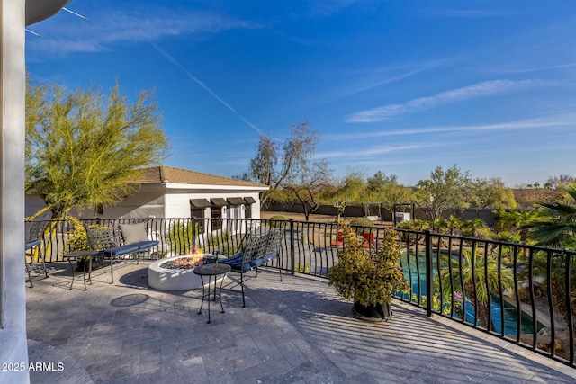 balcony with an outdoor fire pit and a patio area