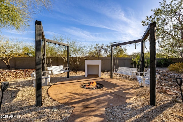 view of patio / terrace with an outdoor fire pit and fence