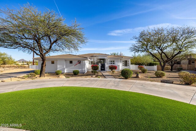 10800 E Cactus Rd Unit 7, Scottsdale, AZ 85259 - mediterranean / spanish house with curved driveway, fence, and a front lawn