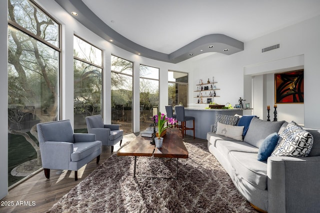 living area featuring recessed lighting, visible vents, and wood finished floors