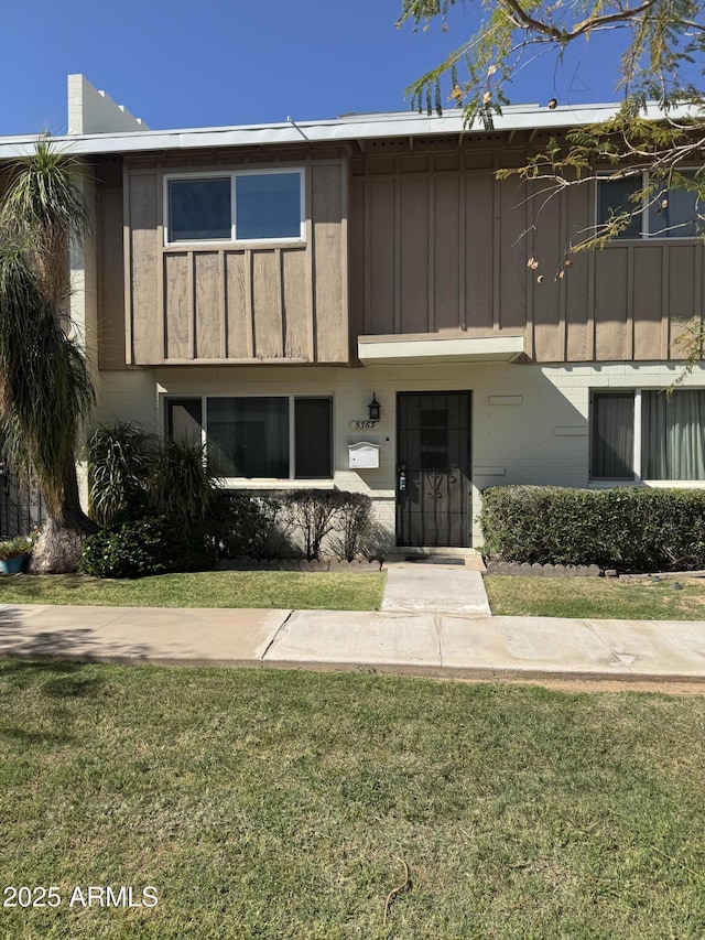 5363 N Black Canyon Highway, Phoenix, AZ 85015 - view of front of property with board and batten siding and a front lawn