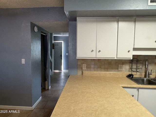 5363 N Black Canyon Highway, Phoenix, AZ 85015 - kitchen featuring tasteful backsplash, a textured wall, light countertops, white cabinets, and a sink
