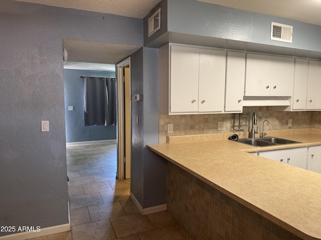 5363 N Black Canyon Highway, Phoenix, AZ 85015 - kitchen with baseboards, a textured wall, white cabinetry, visible vents, and a sink